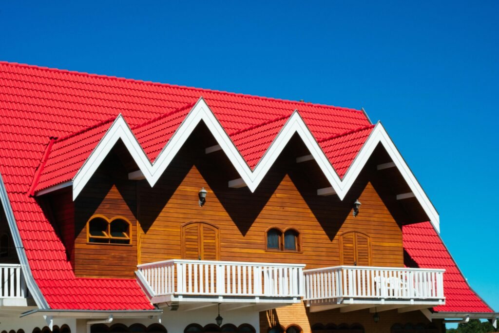 Charming home with red tile roof and wooden facade against clear sky.