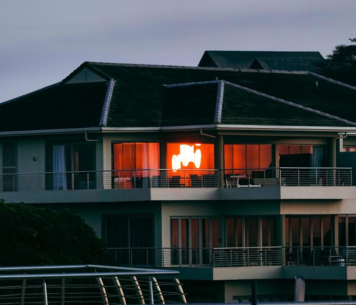 Elegant modern house on Dolphin Coast, South Africa, reflecting the warm glow of the sunset.