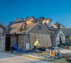 Workers engage in roof replacement on a brick house in Fort Worth, Texas.