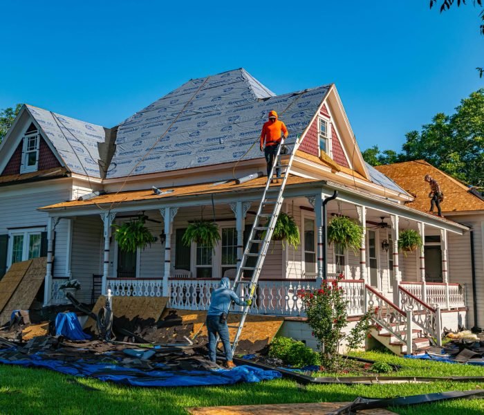Roofers replace the roof of a historic home in Weatherford, Texas.