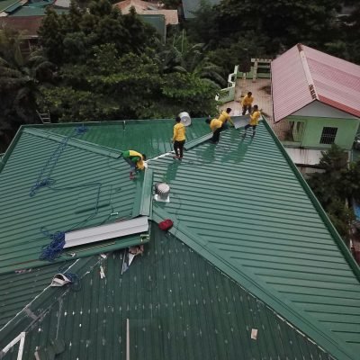 Workers installing green roof panels in Caloocan, Philippines.