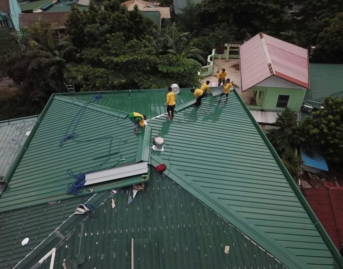 Workers installing green roof panels in Caloocan, Philippines.