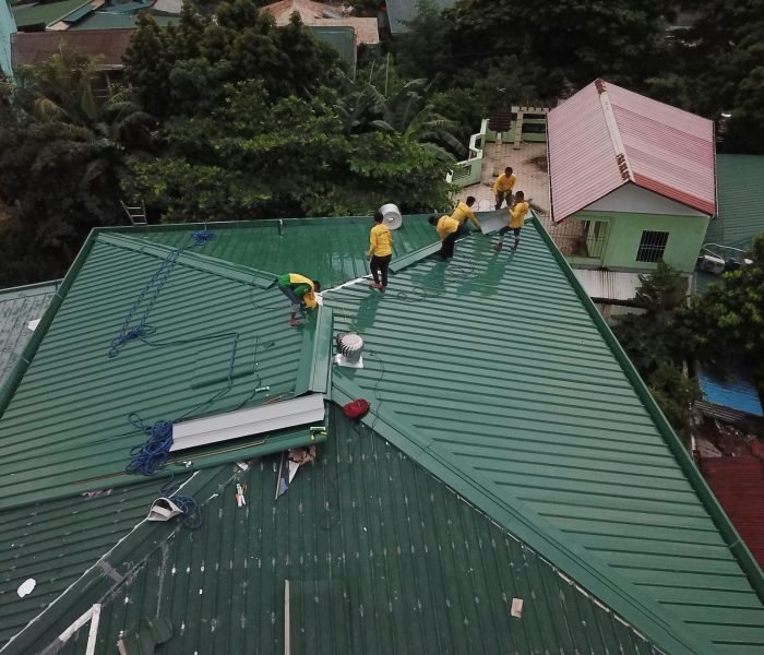 Workers installing green roof panels in Caloocan, Philippines.